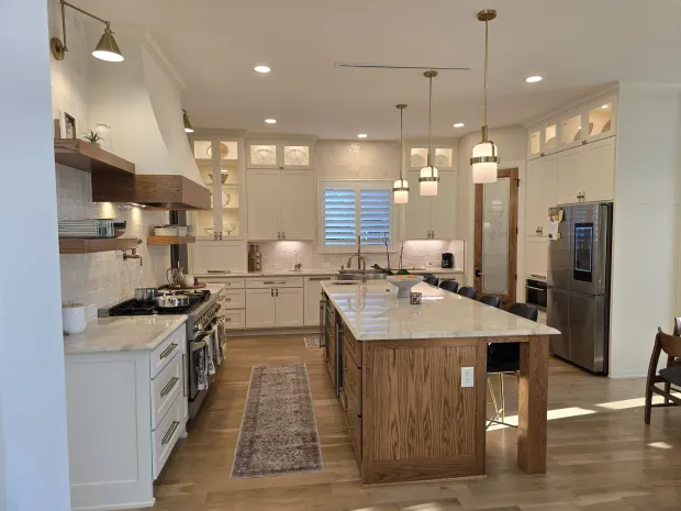 Finished kitchen with white painted cabinetry, a white range hood, and a natural oak island